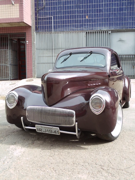 an old fashion car parked on a city street