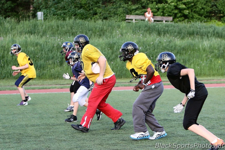 a boy with a helmet running while holding onto a football