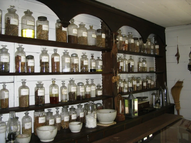 shelves full of small, round glass jars and jars with lids