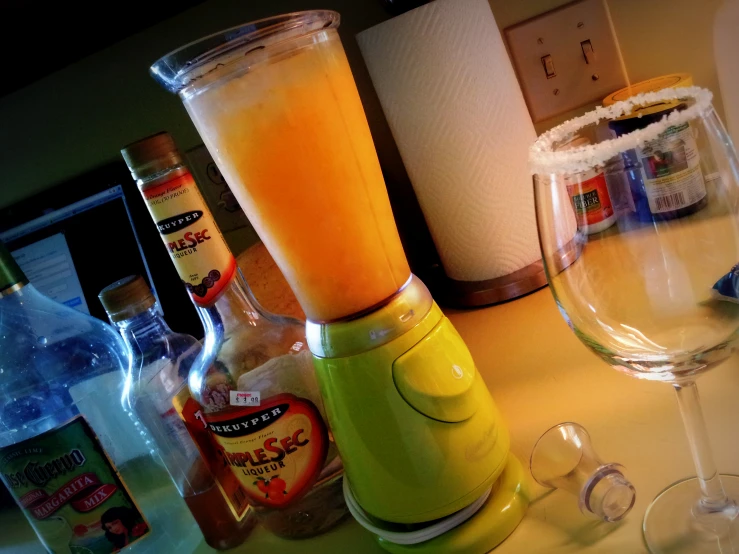 an orange juice inside a blender next to some liquor