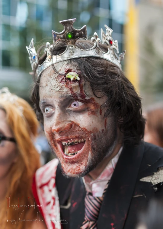a costumed man with red makeup and a crown