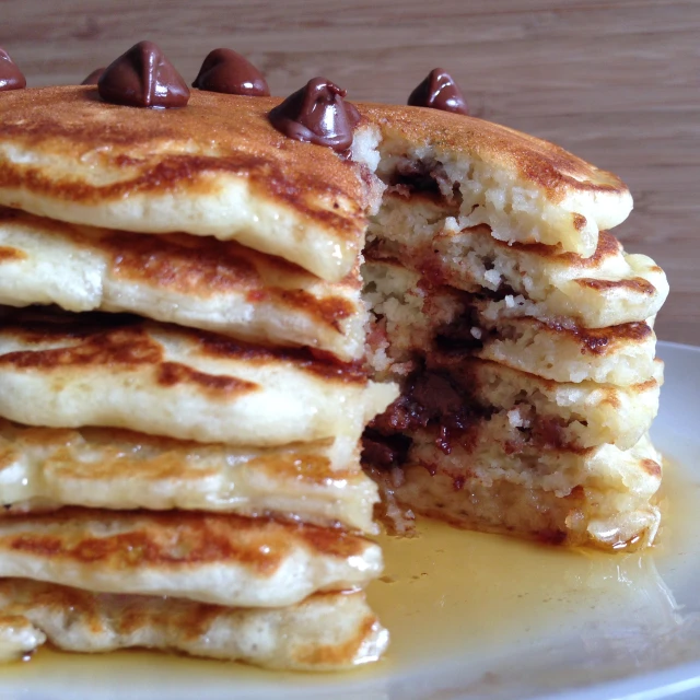 a stack of pancakes with chocolate syrup on top