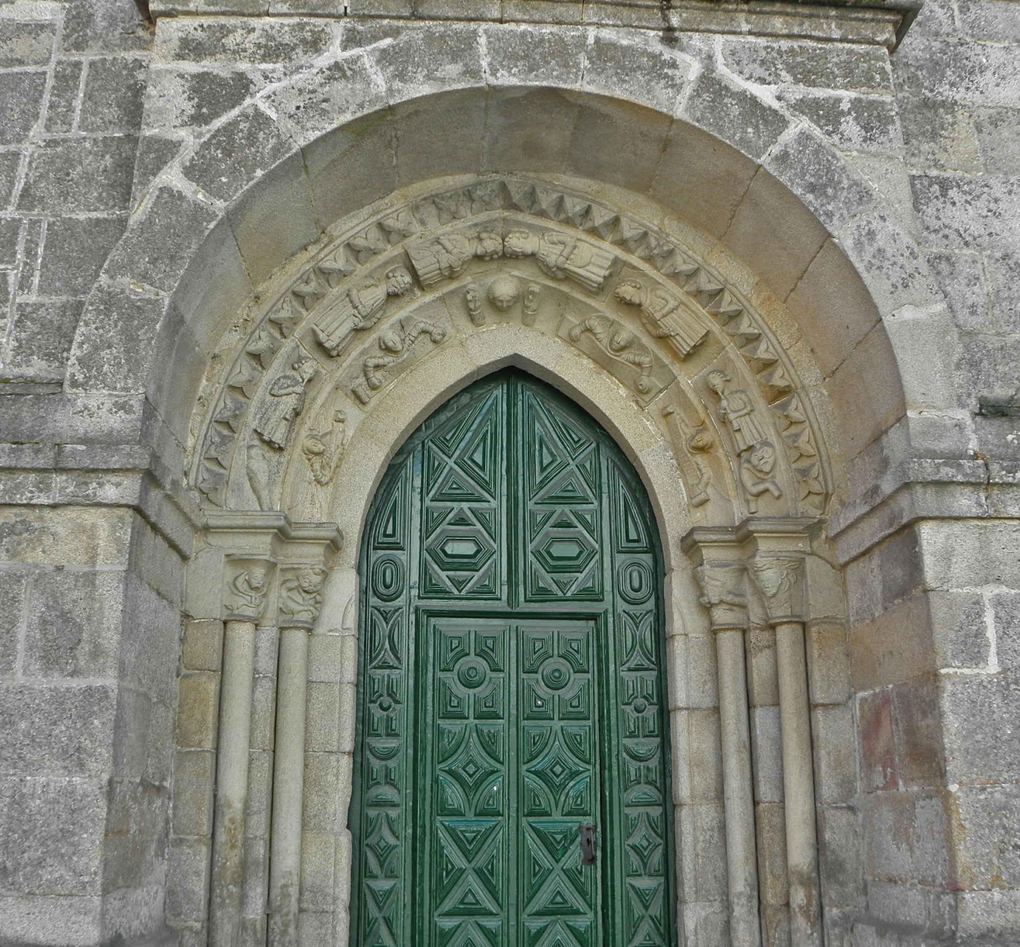 an old building has a green door on the side