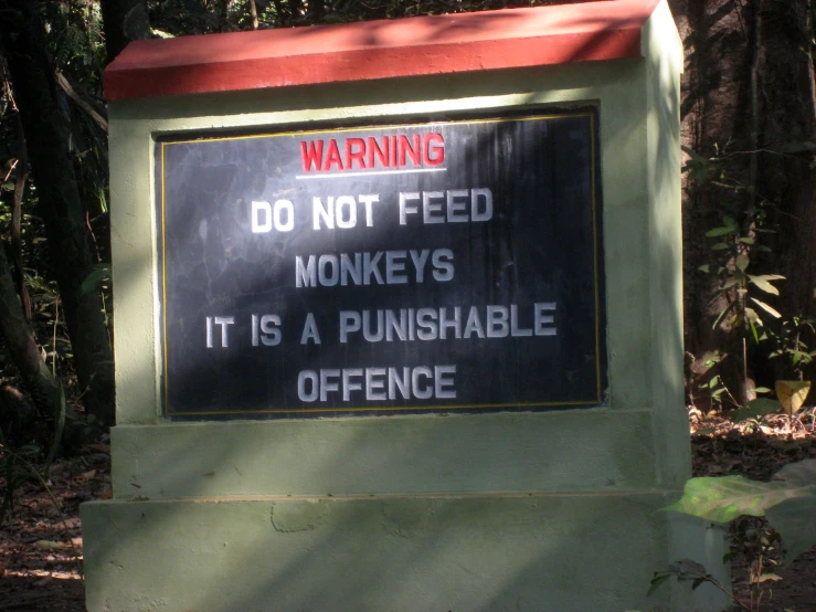 a warning sign that says don't feed monkeys it is a gunhabe office
