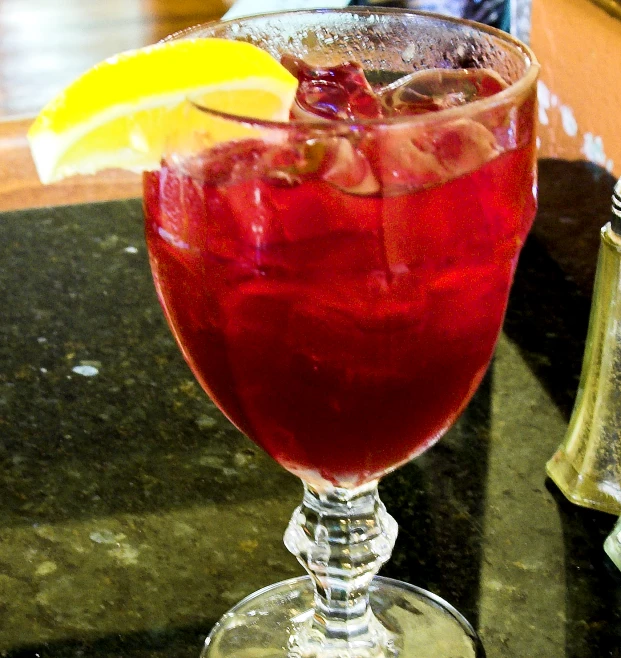 an alcoholic beverage with a fruit on the rim