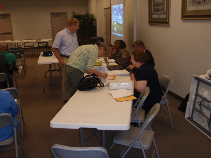 a group of people in a large room with chairs and tables