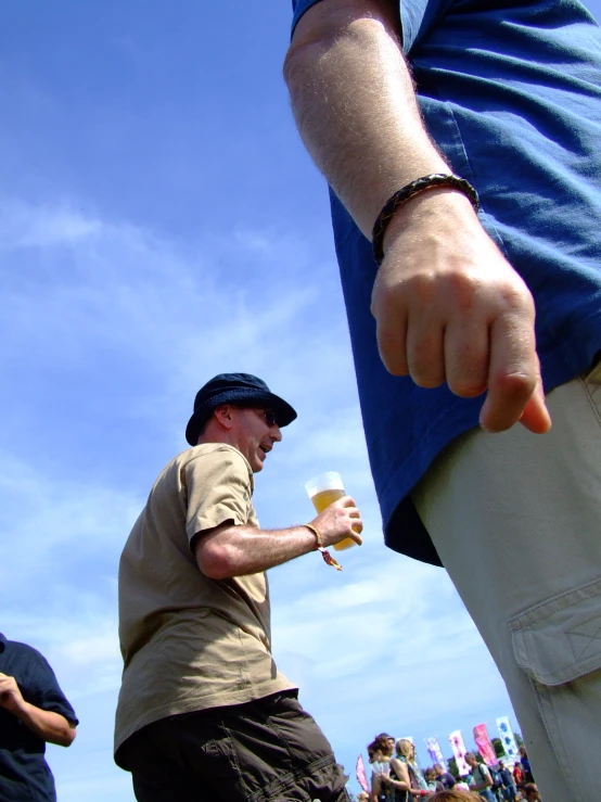 the man holding an ice cream cone is pointing to the sky