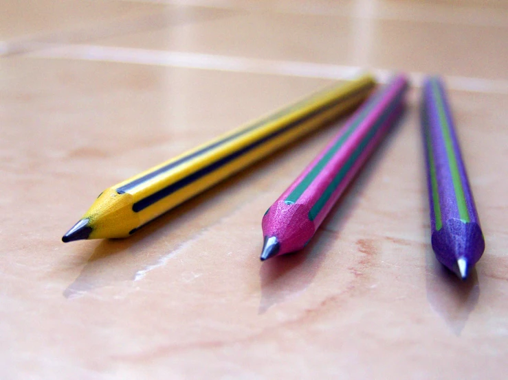 three pencils sit side by side on the ground