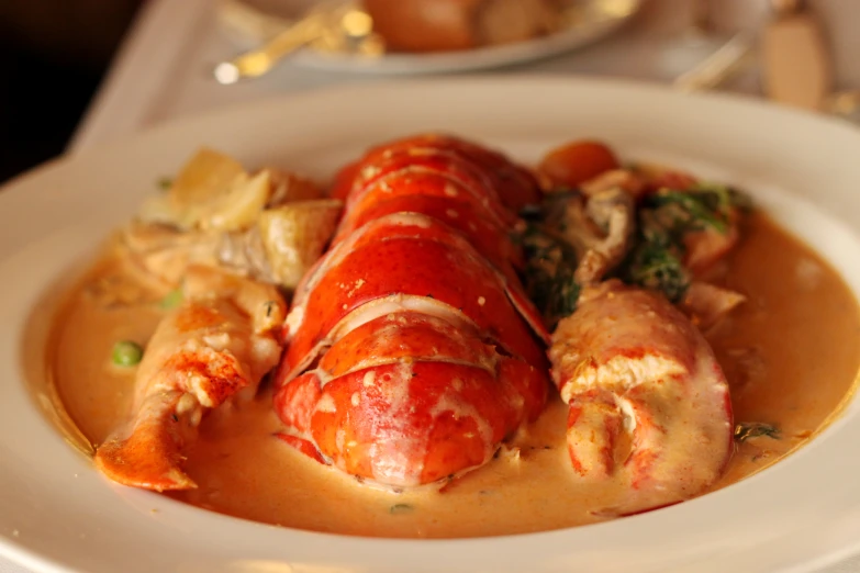 lobsters, potatoes and broccoli are on a dish in a white plate