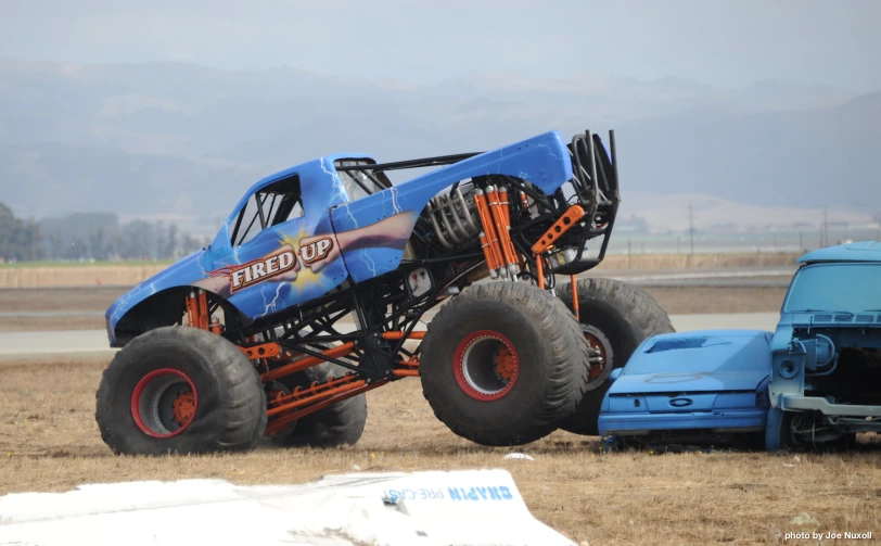 a very large truck with huge tires on a dusty track