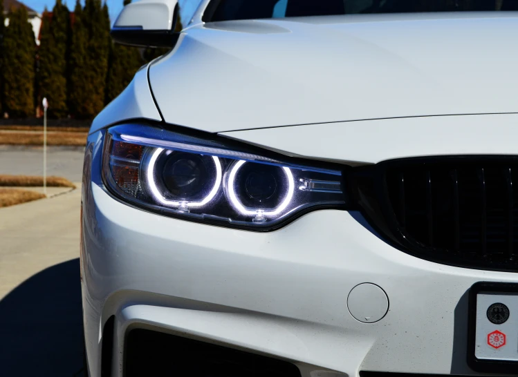 the front view of a white bmw with its headlights