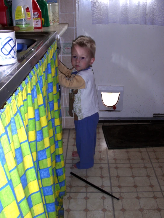 a  standing in the kitchen with his hands on a sink