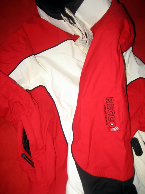 a jacket with white and black stripes, on a red and white blanket