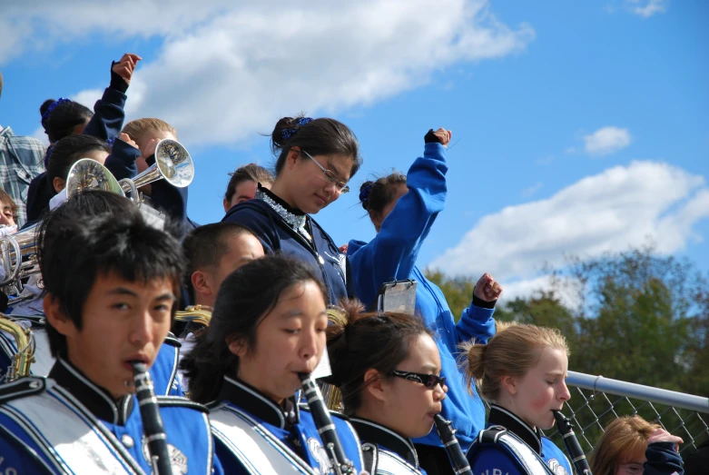 the boys and girls cheer as they watch a marching game