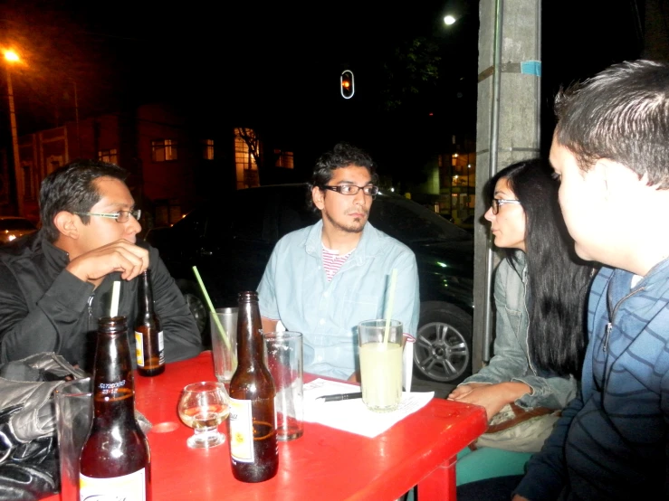 group of people sitting at table outdoors drinking drinks