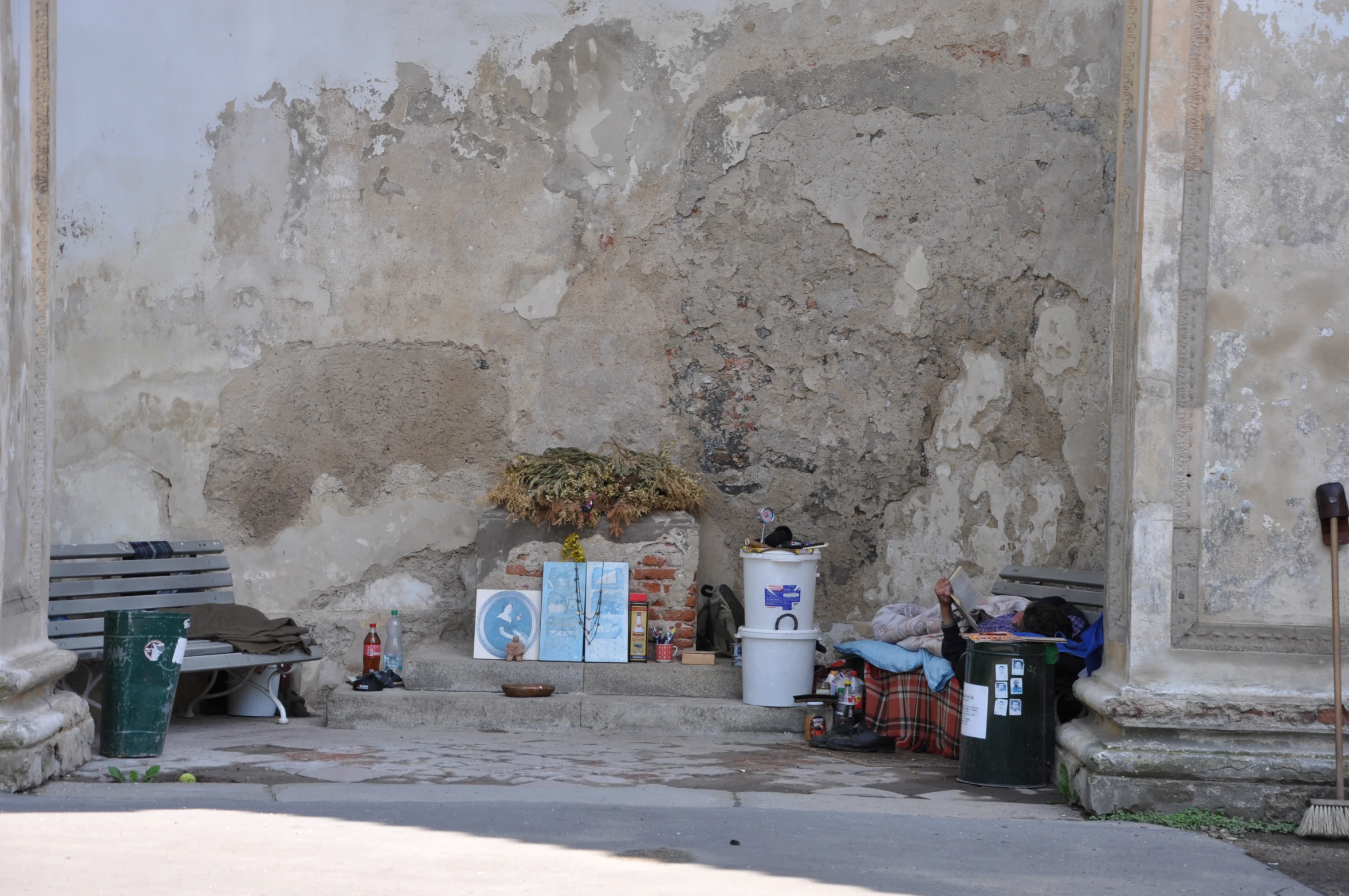 a pile of trash is sitting in front of a wall with a bunch of signs on it