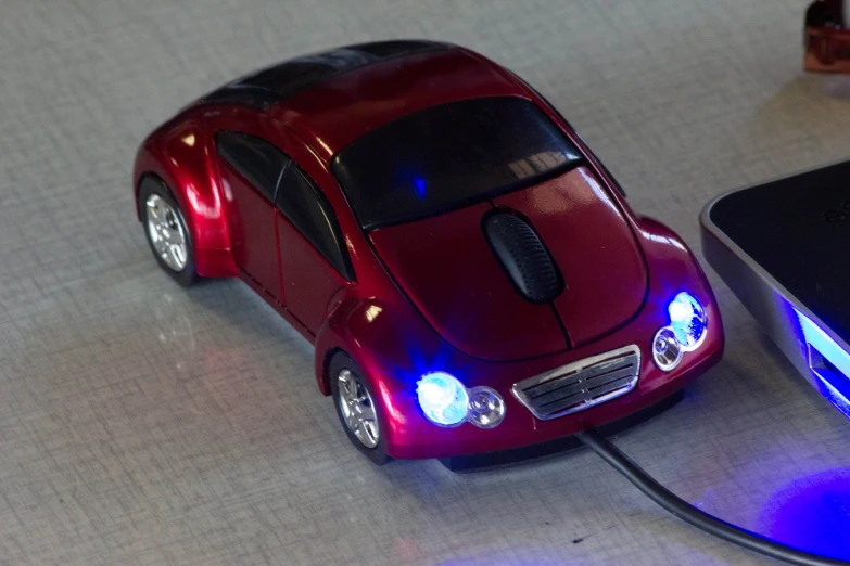 a small toy car is plugged into a laptop computer