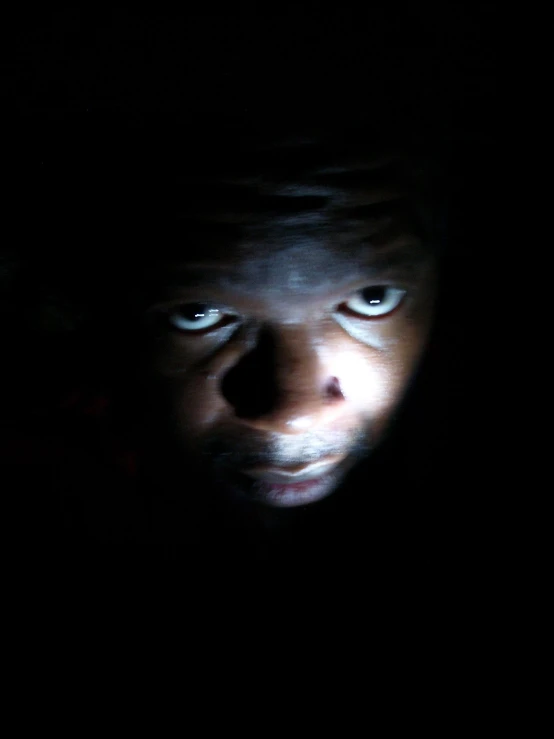 a man is staring into the distance in the dark