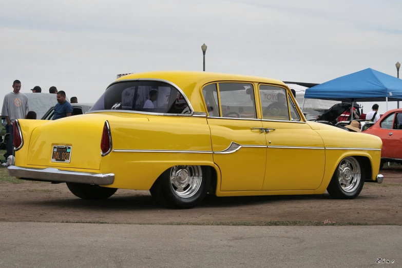 a bright yellow car sits parked on a lot