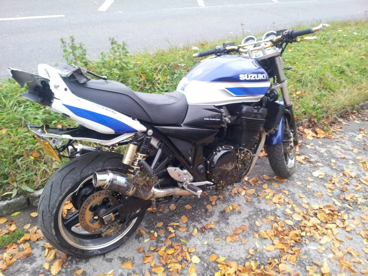 the motorcycle is parked in the grass by the street