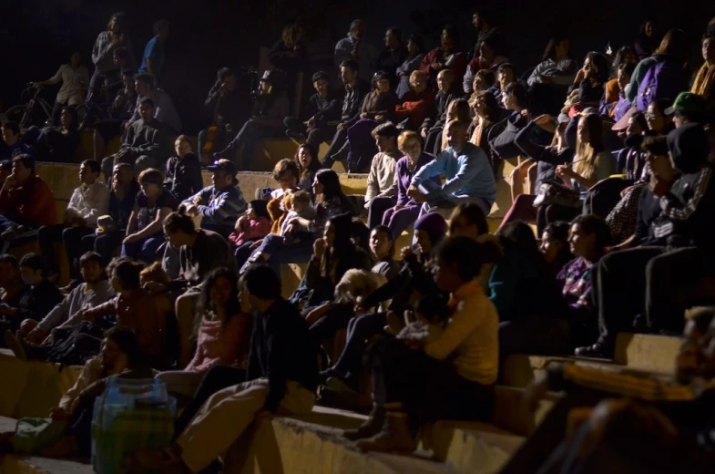 a big crowd is in the bleachers at night