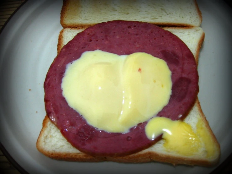 there is a sandwich with mustard on it and heart shape