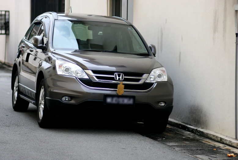 a silver vehicle parked on the street next to a building