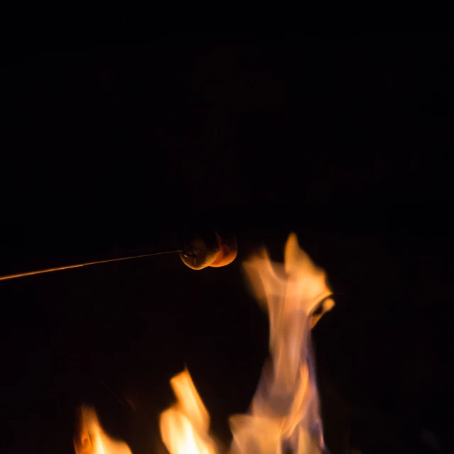 a person standing in the dark holding soing that appears to be a light bulb