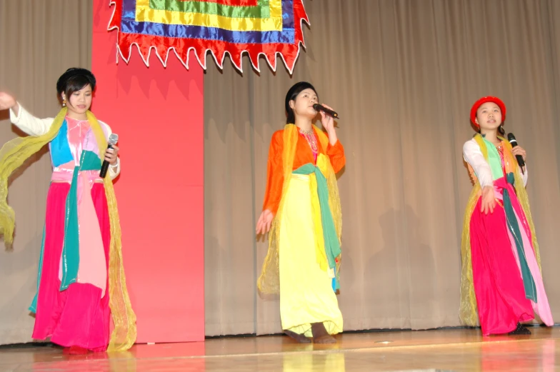people on a stage performing with bright colored dresses