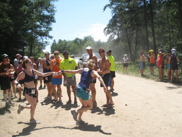 two people trying to grab soing by their hand while others watch