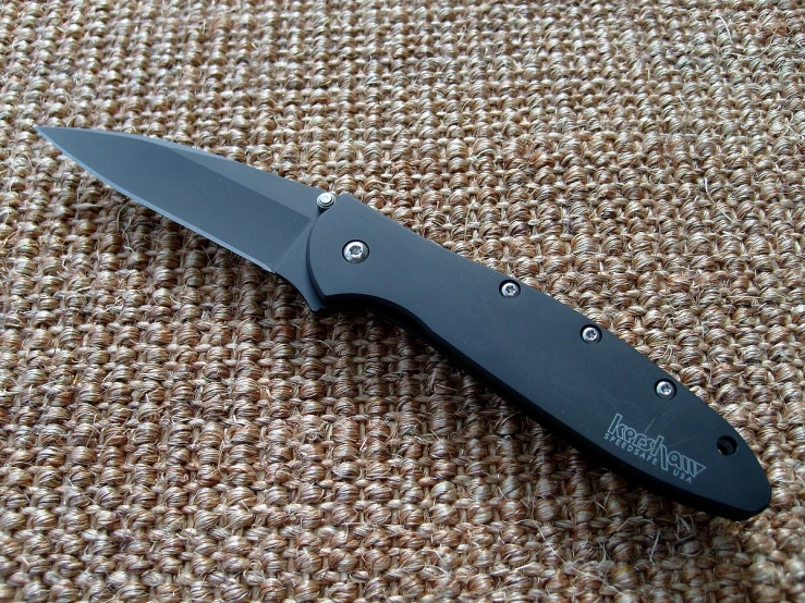 a small knife with metal studs on the blade