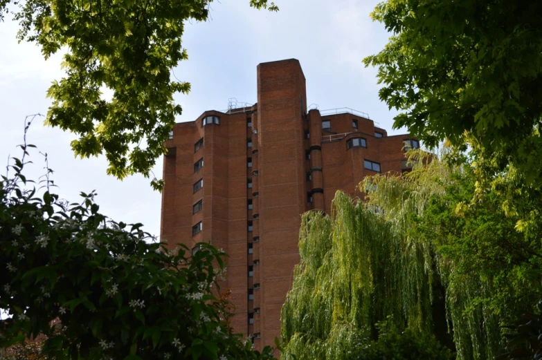 a large tall building behind some green trees