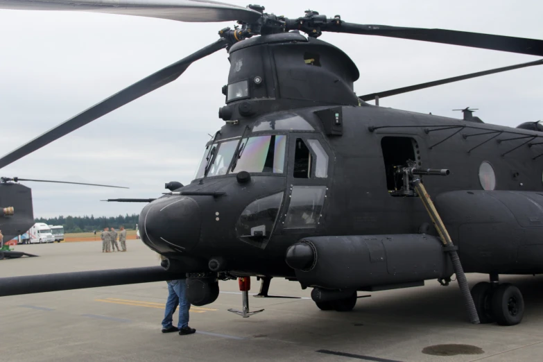 the man stands next to a black helicopter