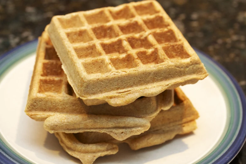 a pile of waffles on a plate that have been stacked high