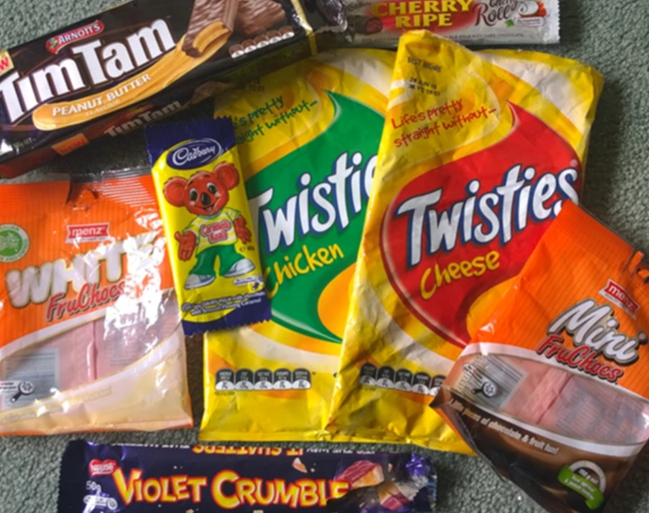 variety of food on carpet next to bottle of soda