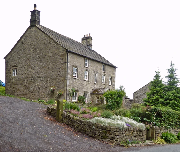 a brick house with a stone fence around it