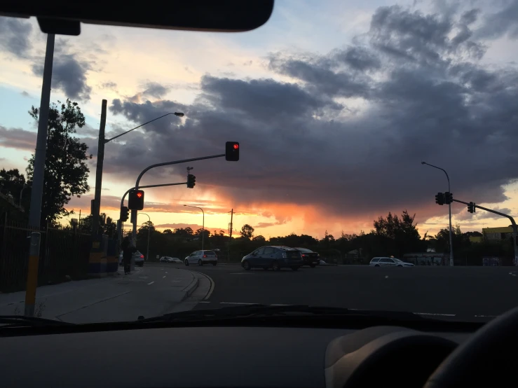a sunset view from inside a car at a street intersection