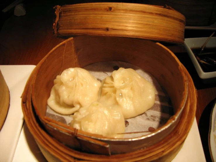 a bamboo steamer tray filled with dim steamed dumplings