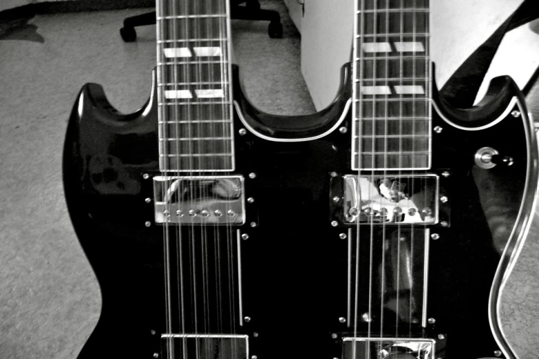 two black electric guitars laying next to each other