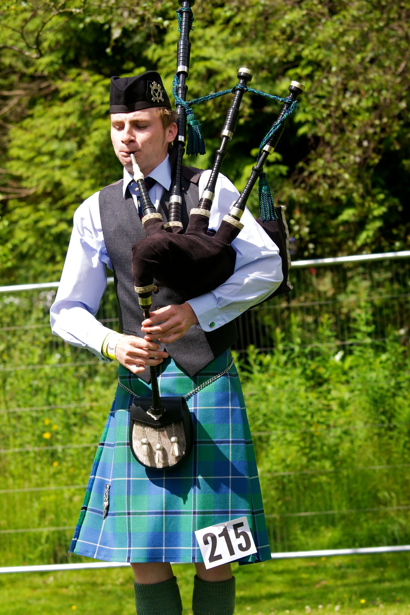 a person in a kilt holds two bagpipes