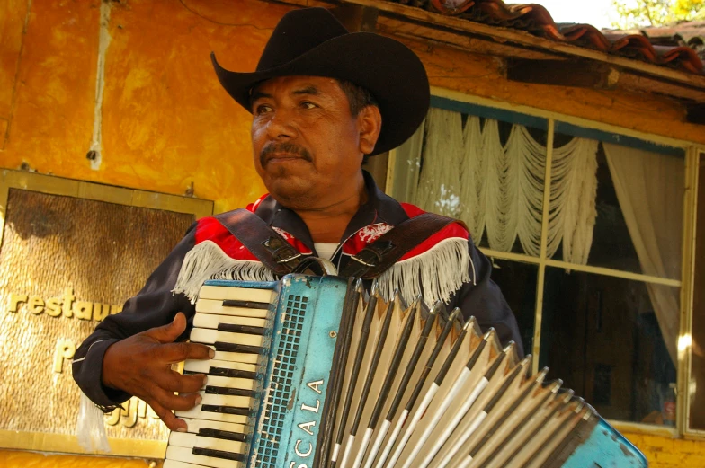 an old black man playing an accordian outside