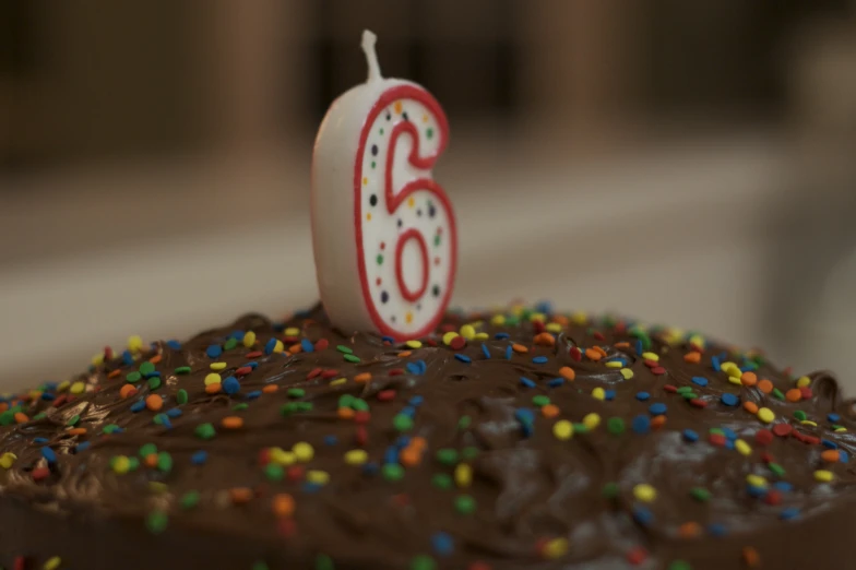 this cake has a candles shaped as the number sixty on it