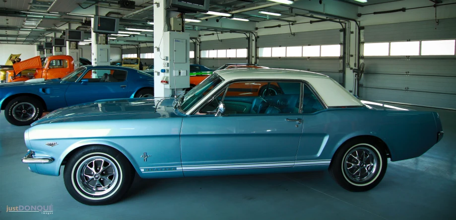 two old cars in a garage next to each other