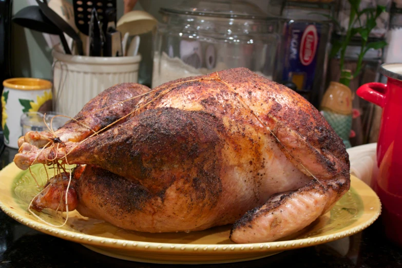 a cooked turkey sits on a yellow plate