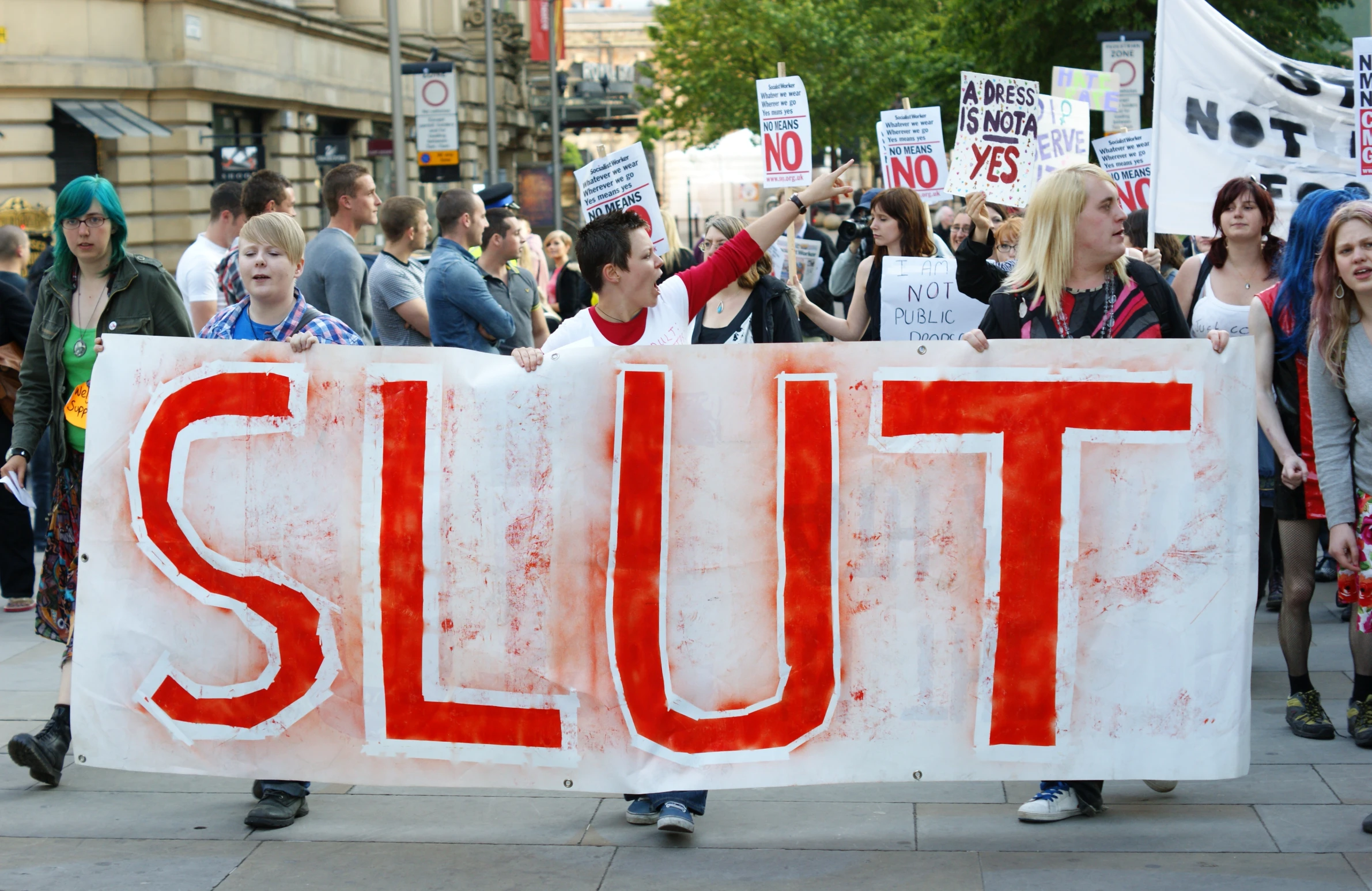 a group of people holding a big sign in the street