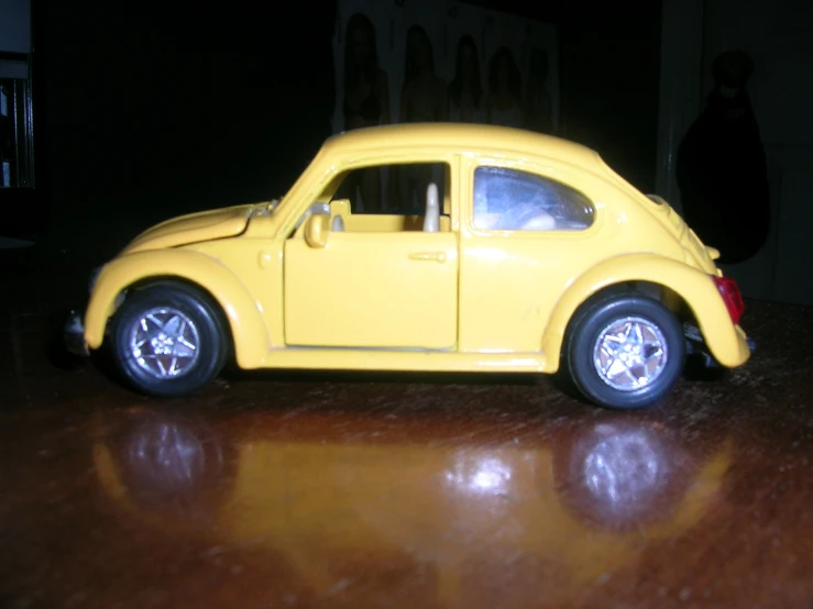 a toy car sitting on a table next to a cat