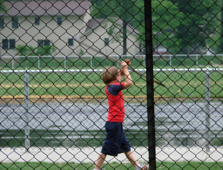  playing tennis outside on a grass area