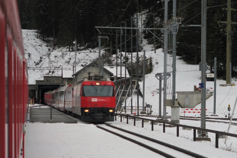 a train is coming in to the snowy railroad station