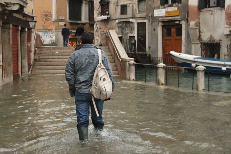 a person wearing boots is walking in a flooded area