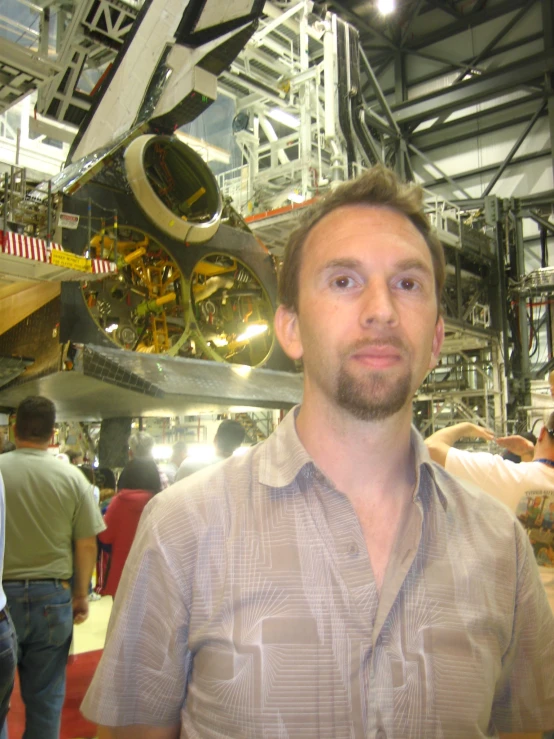 man in front of aircraft displayed on museum floor